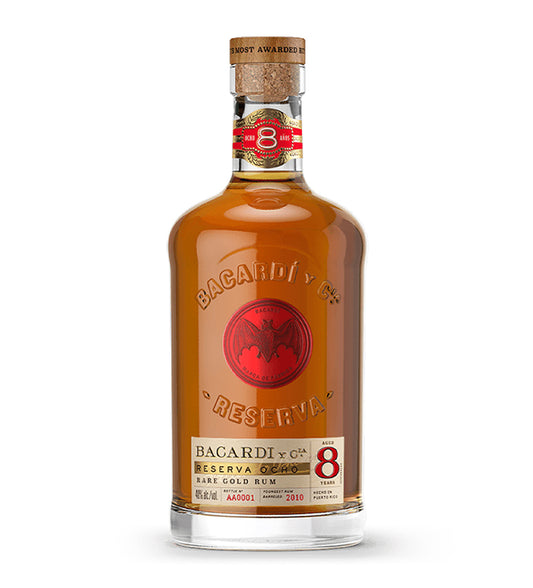Bacardi 8 Años aged rum 1L amber glass bottle on white background, dark spirit with gold and black label featuring bat logo