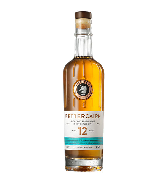 Fettercairn 12 Years Highland Single Malt Scotch Whisky 70cl clear glass bottle on white background, golden amber spirit with cream and turquoise label featuring unicorn emblem