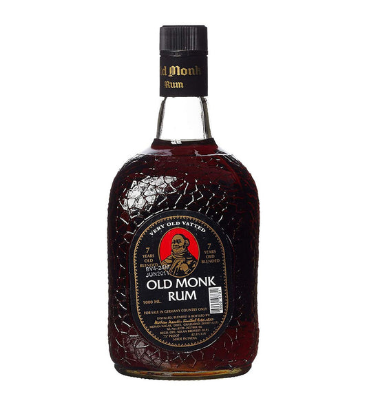 Old Monk Indian dark rum 1L dark glass bottle on white background, textured bottle with black and gold label featuring monk illustration
