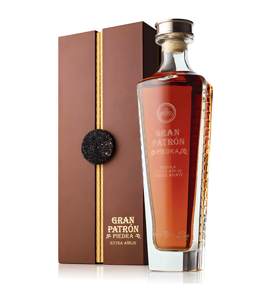Patrón Piedra Tequila 75cl round decanter-style bottle on white background, rich amber spirit with cork stopper and embossed label